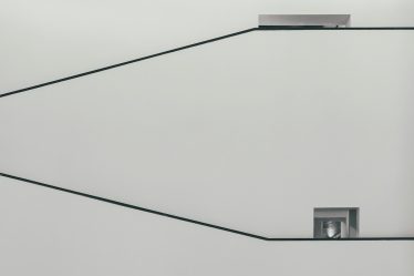 a black and white photo of a square object on a wire
